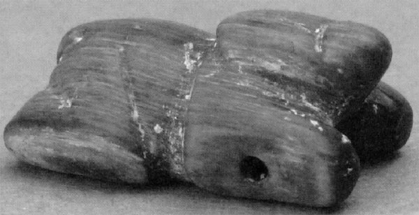 Amulette en pierre verte (grenouille) au cou d'un squelette humain datée entre 120 et 590 après J.C.