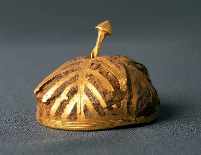 Artefact extraterrestre, une hémisphère de fer creux recouvert de feuilles d'or, d'un diamètre d'environ 4,5cm.