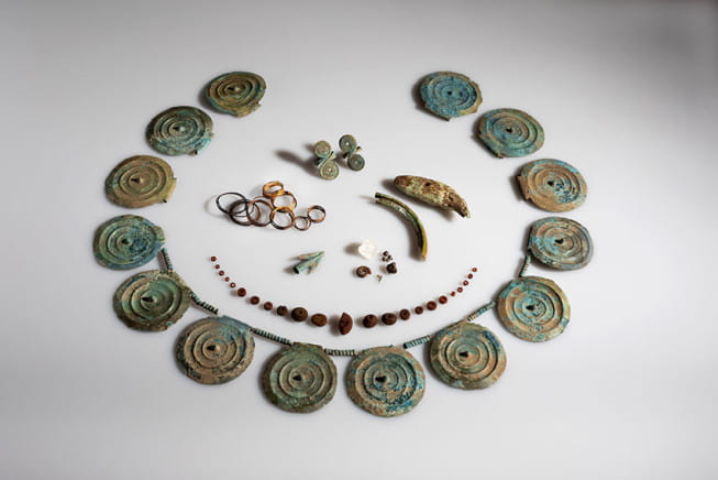Collier de disques, collier de perles d'ambre, dents d'ours et castor, ammonite.
