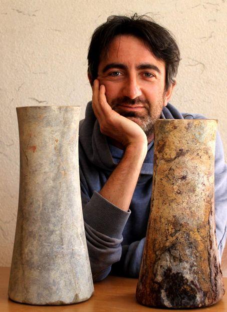 François Desset, archéologue au Laboratoire Archéorient (Lyon), professeur à l'Université de Téhéran (Iran), encadré par des colonnettes funéraires retrouvées dans des tombes du 3e millénaire avant J.-C, au Balouchistan iranien.