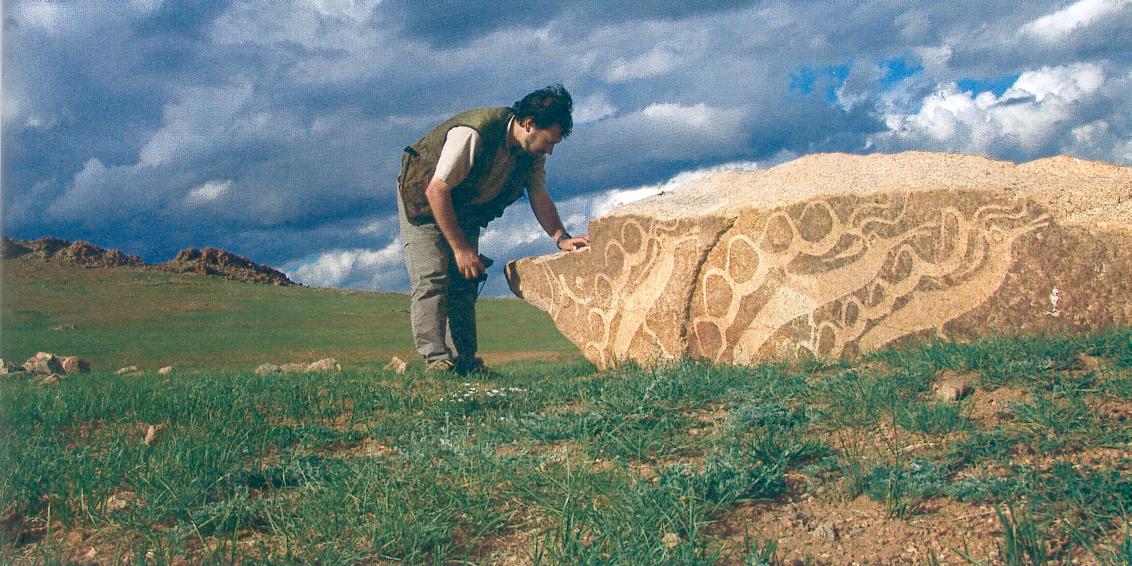 Menhirs en Mongolie, sur le site de Tsatsiin Ereg, avec un tumulus en arrière-plan.