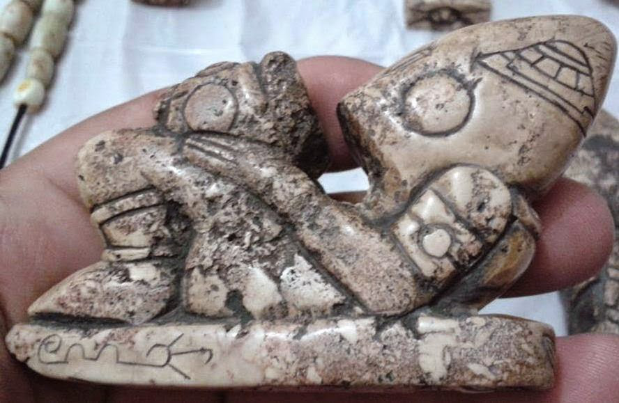 Statuette d'un pilote à trois doigts, ufo dessiné sur son crâne allongé.
